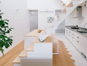 cocina con escalera hacia la planta superior. suelo en parquet de bambú color claro para dar mayor luz a la estancia